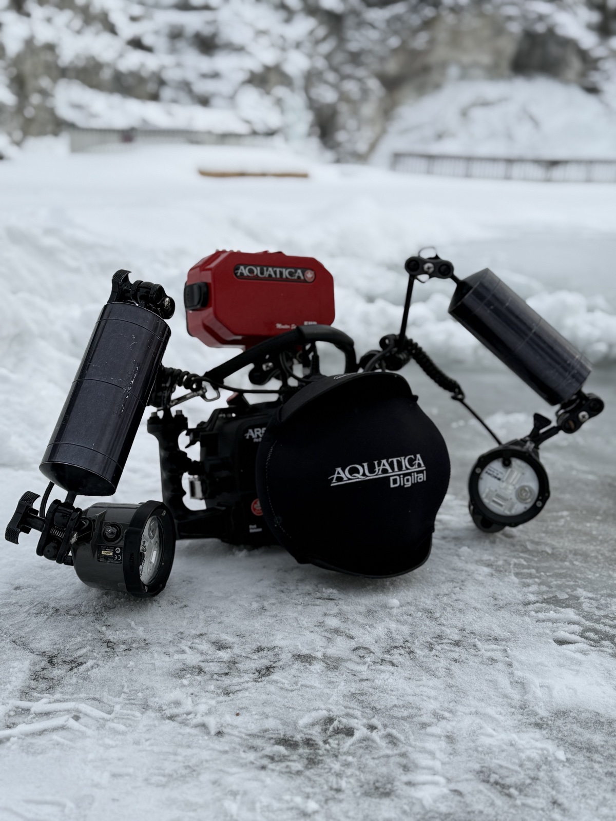 Aquatica underwater camera housing with strobes on snow at Flintkote ice diving site Canada