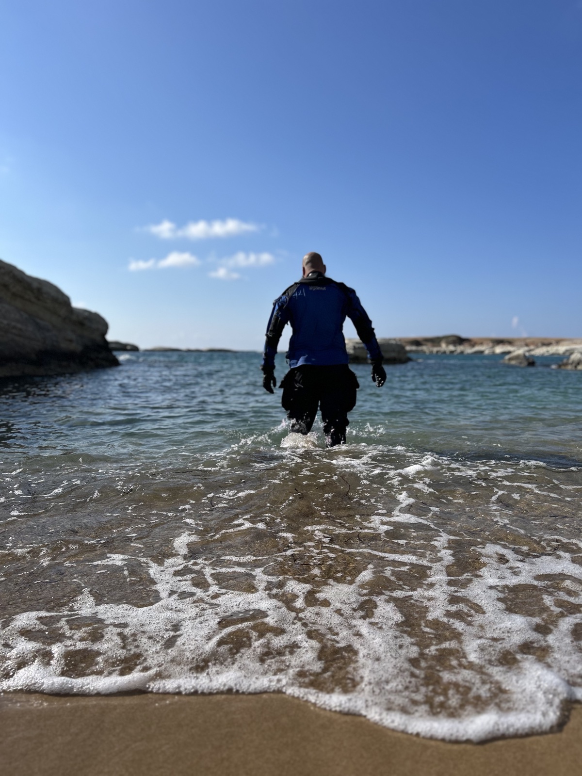 GUE instructor walking into the Mediterranean from a Cyprus shore for a dive
