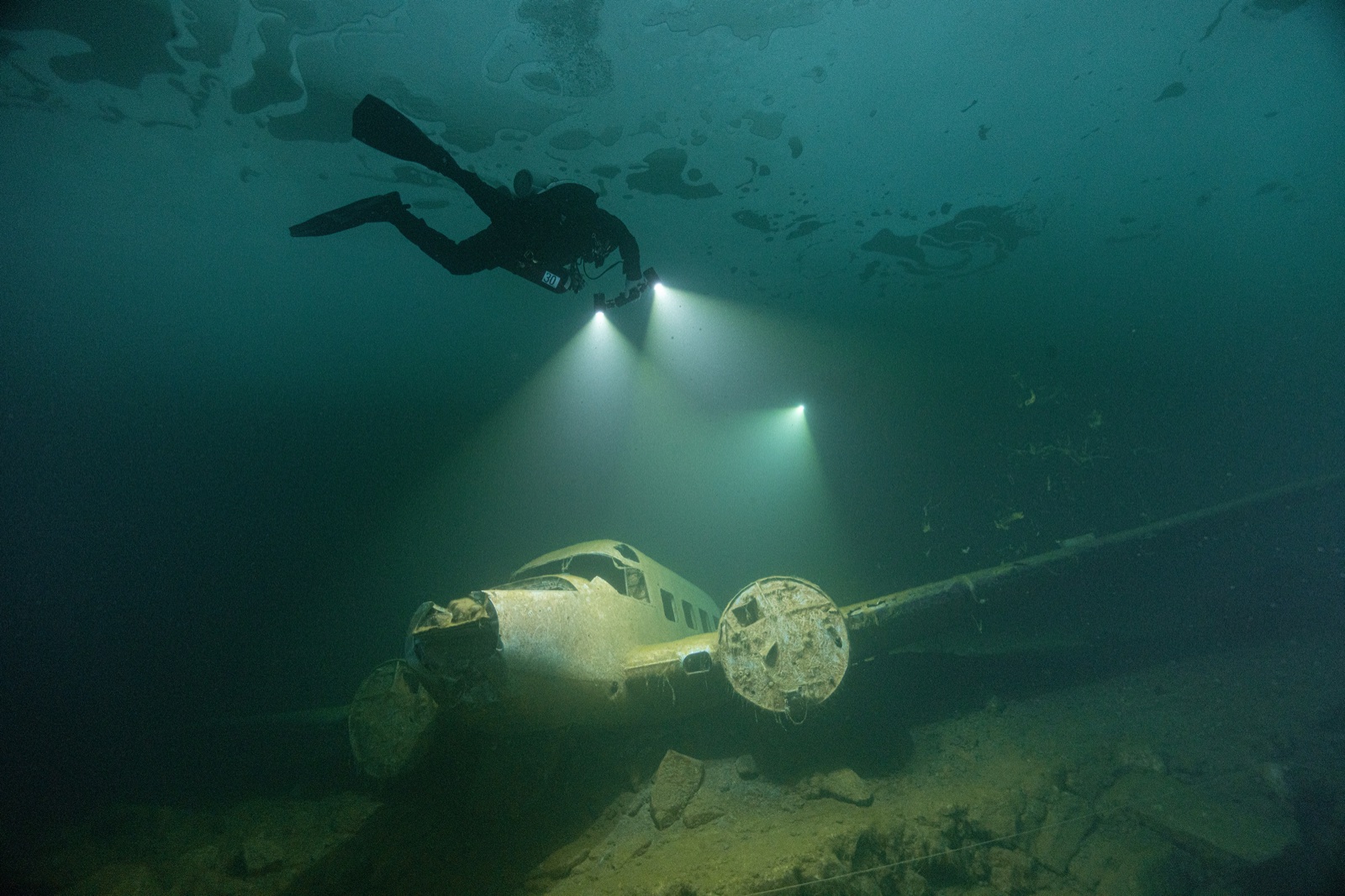 Imad Farhat ice diver hovering above sunken plane wreck at Flintkote Canada